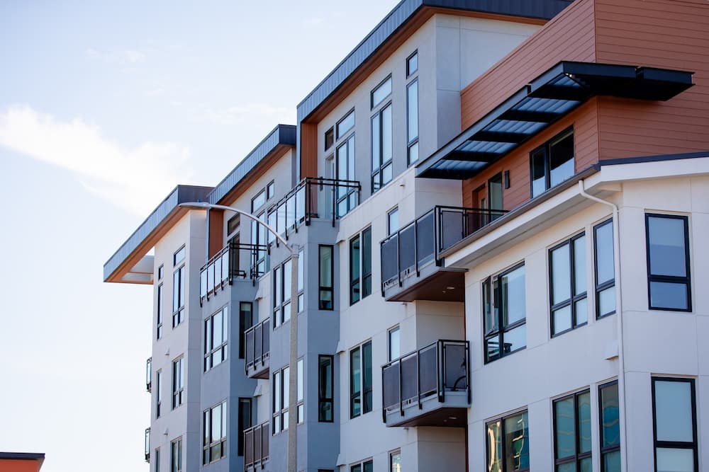Modern multi-story apartment building with balconies and large windows, highlighting professional property management services for residential complexes.